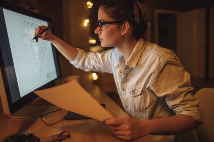 Chef de projet en développement hôtelier travaillant sur un plan depuis son écran tactile