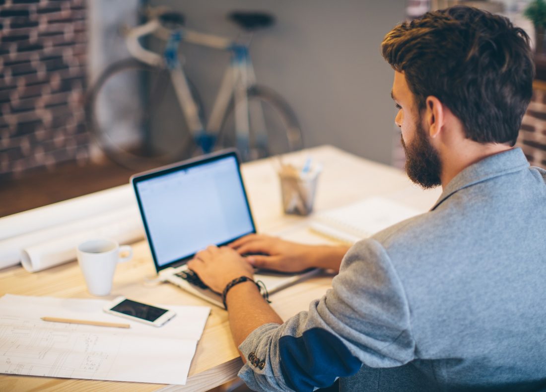 Homme postulant à une offre d'emploi depuis son ordinateur portable